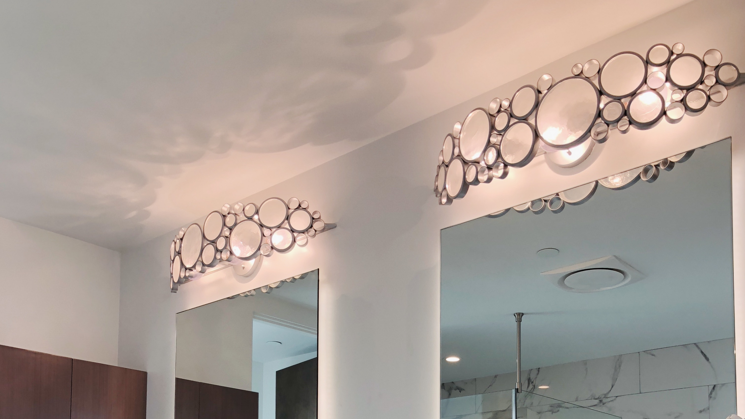 Fascination bath fixtures shown over two mirrors in a bathroom