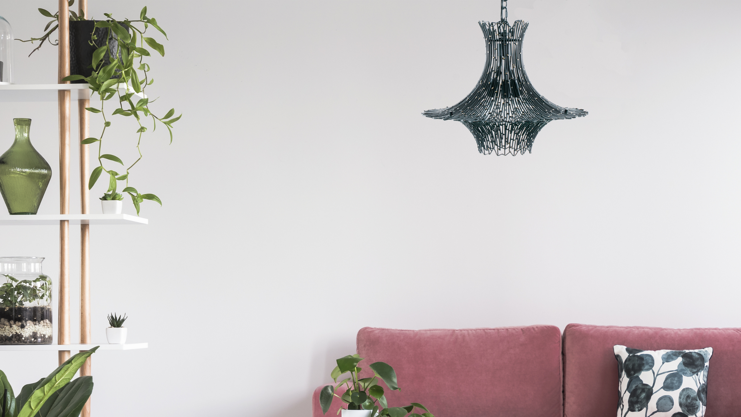 Rikki black steel light fixture shown in room with plants and a pink couch